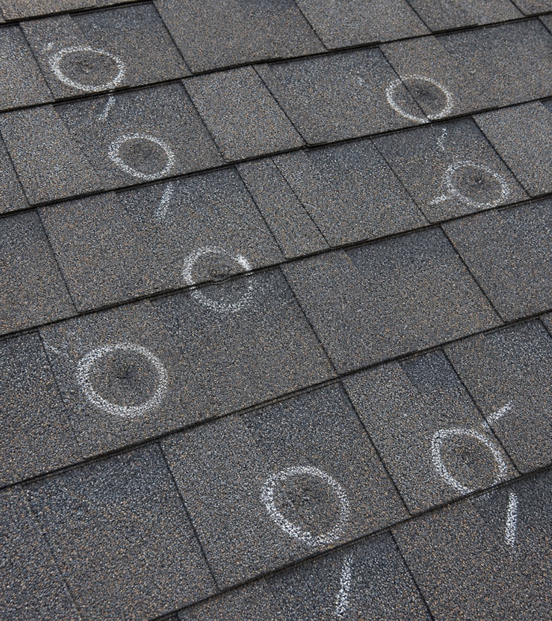 Hail-damaged asphalt shingles marked during a J&K storm inspection