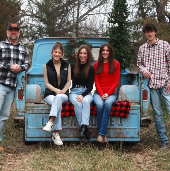 Chad Heusinkvelt with his family by a vintage truck